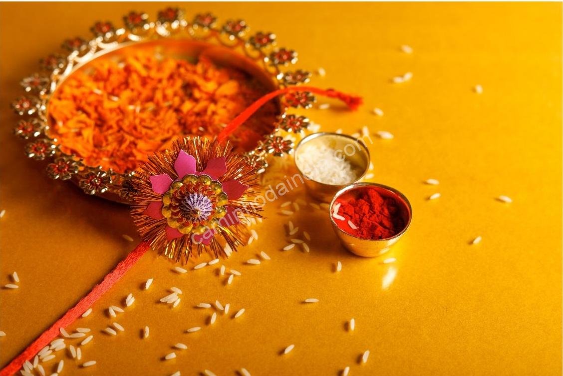 rakhi-itens-celebracao-raksha-bandhan Rakhi disposto em uma bandeja com flores, doces e outros artigos usados no festival de Raksha Bandhan