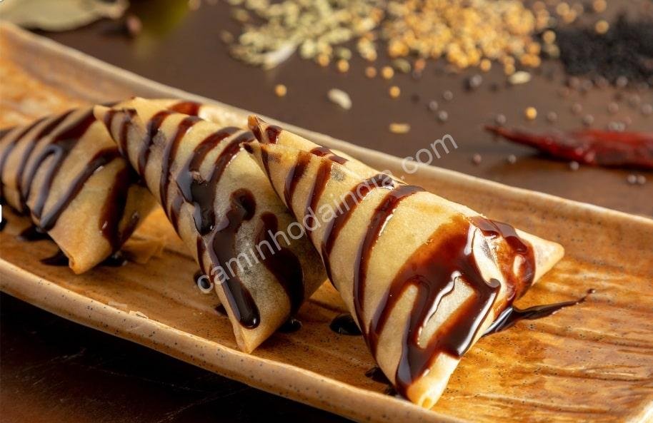 Samosa crocante servida com molho de chocolate picante  