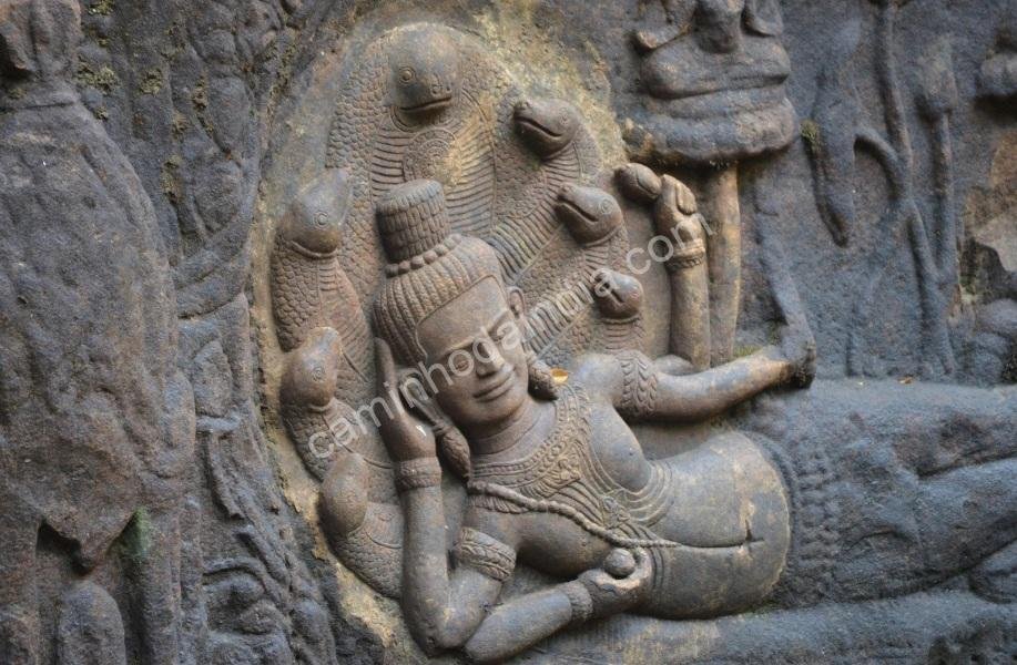Detalhe de uma escultura antiga mostrando Vishnu repousando sob o capuz da serpente Shesh Naag, localizada em um templo histórico da Índia