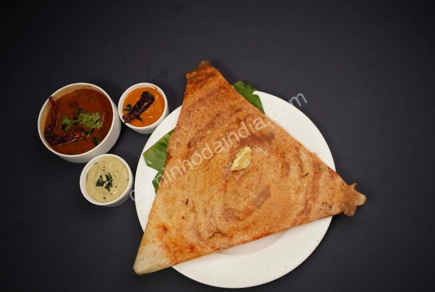 Dosa triangular servida em prato, especialidade tradicional do sul da Índia