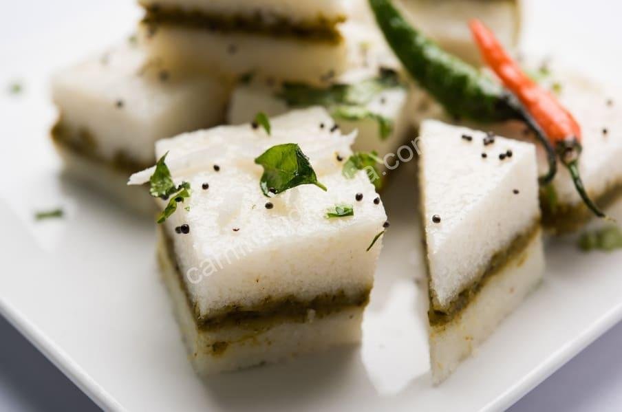 Dhokla preparado como um sanduíche, com camadas leves e recheio saboroso