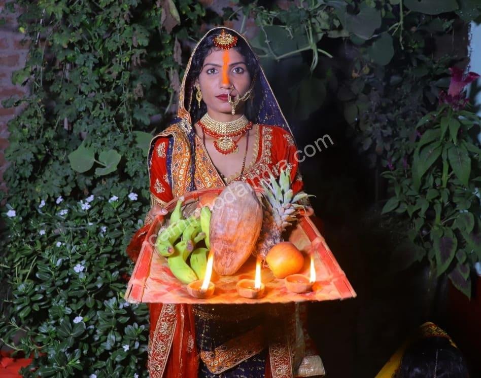 mulher-com-traje-tradicional-bihari-com-thali-durante-chhath-pooja Devota em traje tradicional bihari segura um thali com oferendas enquanto realiza o sagrado ritual do Chhath Pooja
