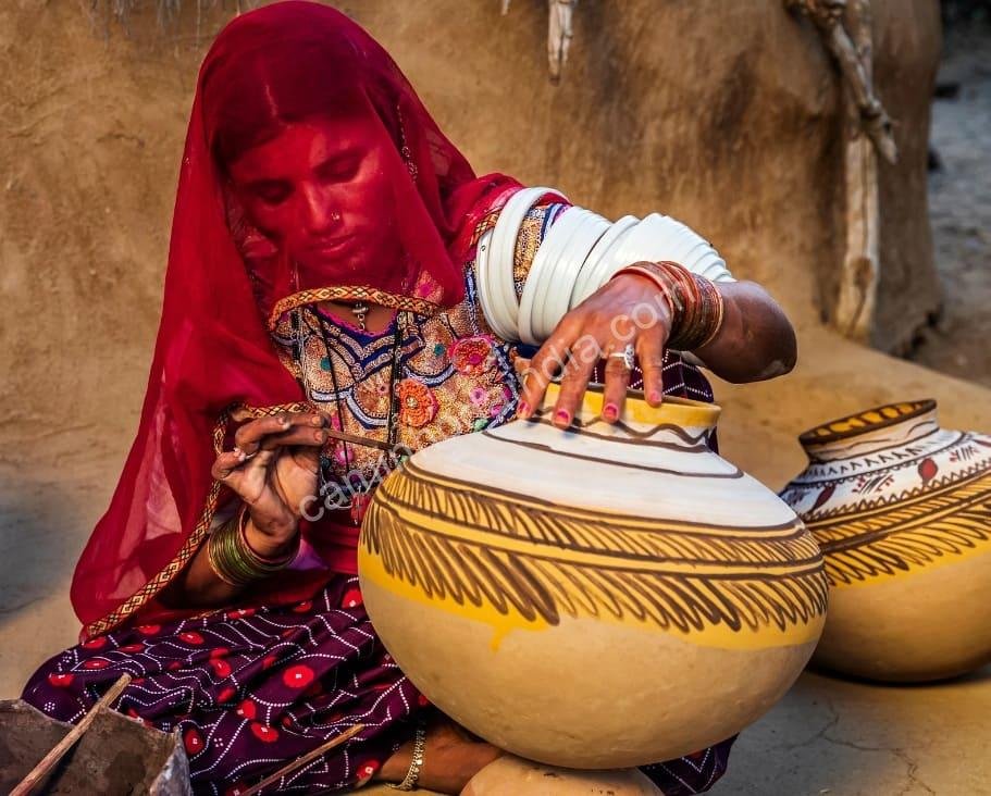 mulher-rajasthani-pintando-um-pote Uma mulher de Rajasthan dedica-se à arte tradicional de pintar potes de barro, símbolo da rica herança artesanal do estado