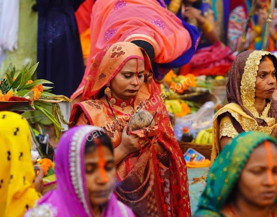 mulheres-rezando-na-margem-do-rio Mulheres em oração nas margens do rio, expressando devoção e fé durante o ritual sagrado