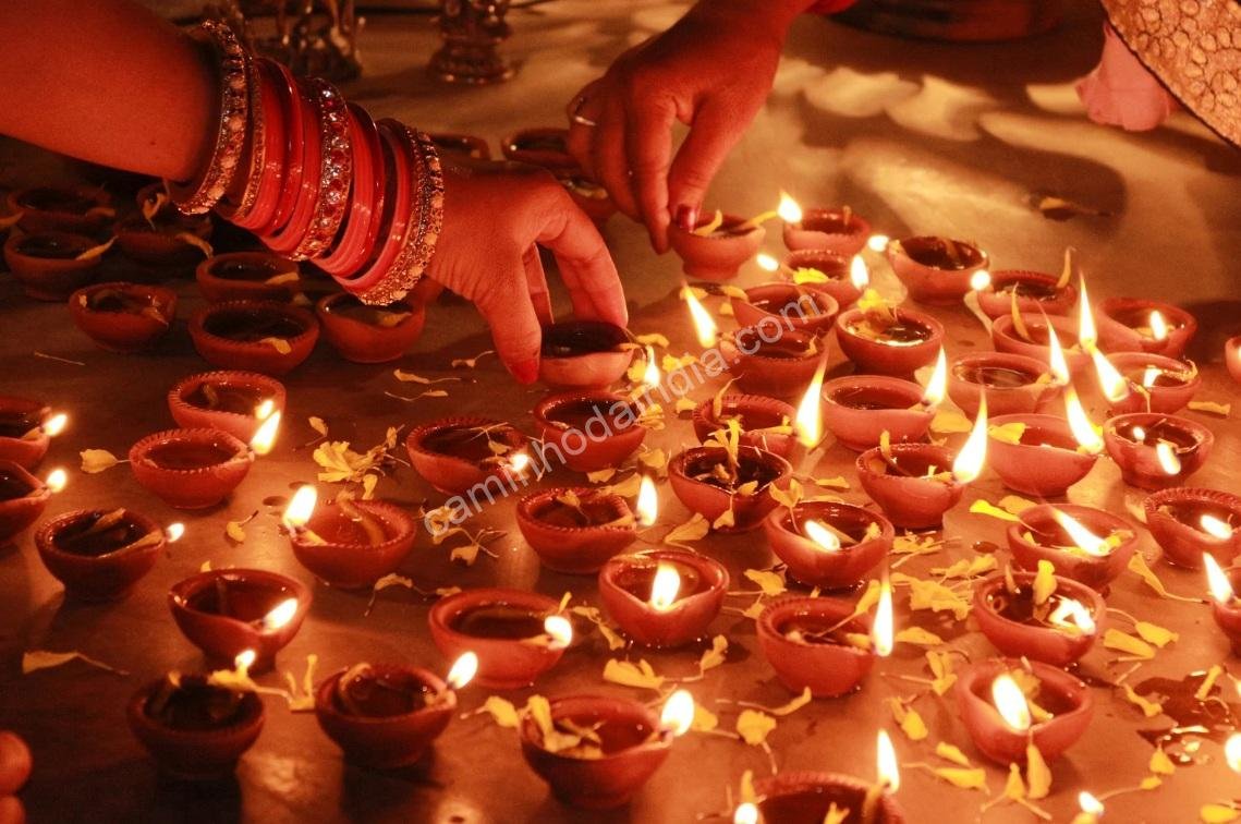 Pessoas arrumando diyas em frente às suas casas durante o Govardhan Puja no período de Diwali